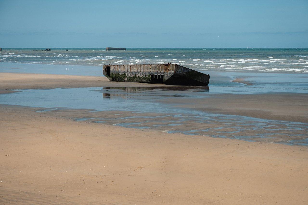 Vestiges du port Mulberry à Arromanches-les-Bains, plage normande historique et vue imprenable sur la mer calme.