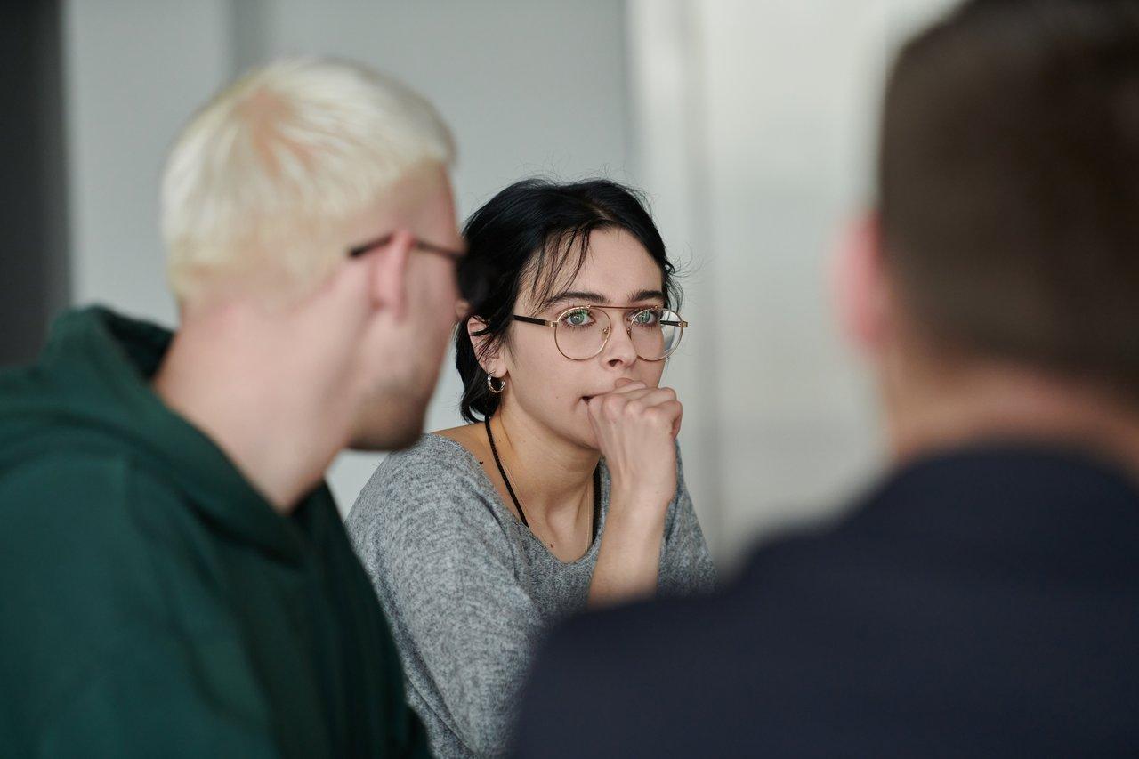 Une discussion dynamique lors d’un atelier collaboratif entre apprenants issus de différentes origines en Normandie.
