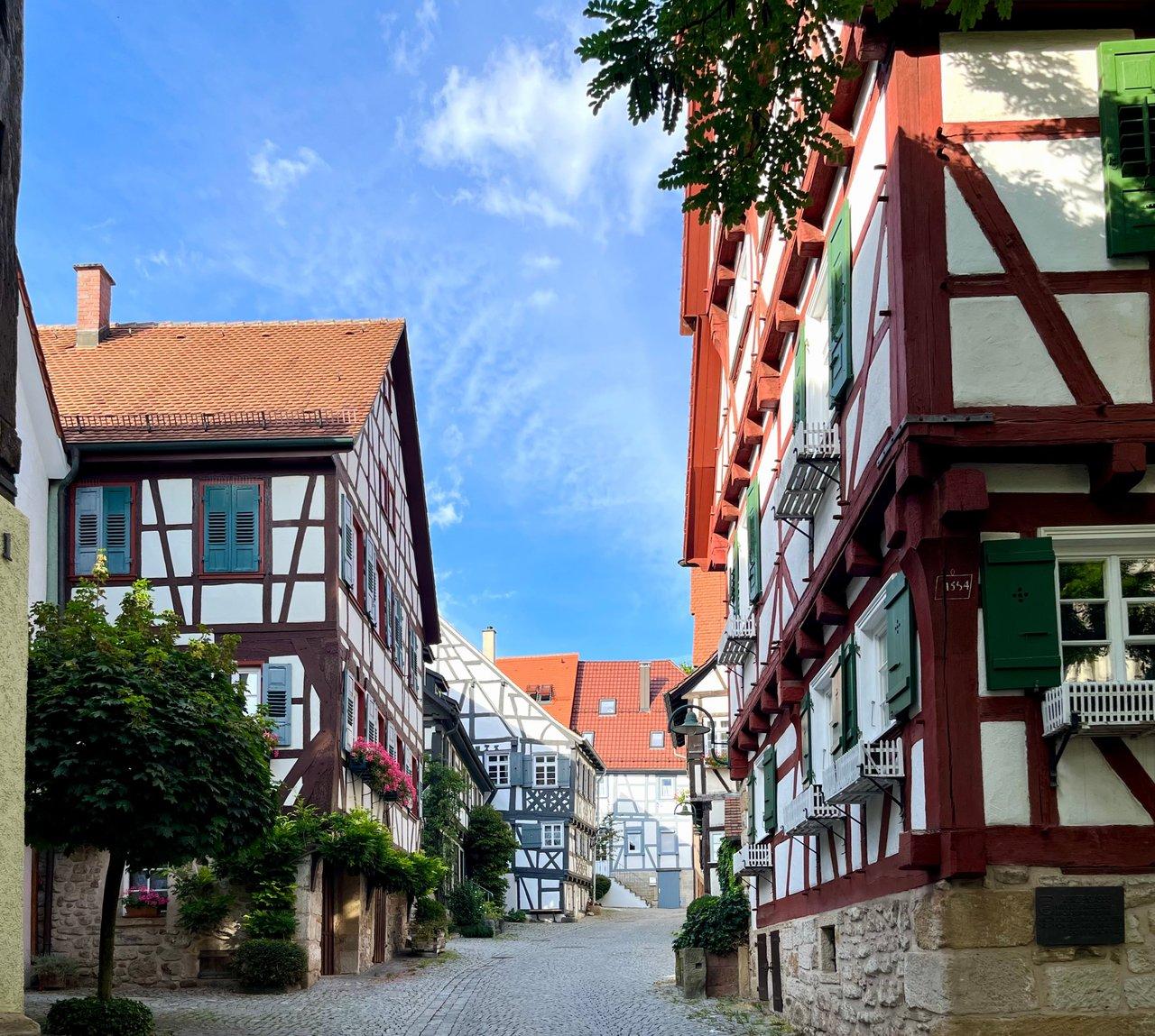 Village typique du Pays d’Auge avec maisons à colombages et marché traditionnel.